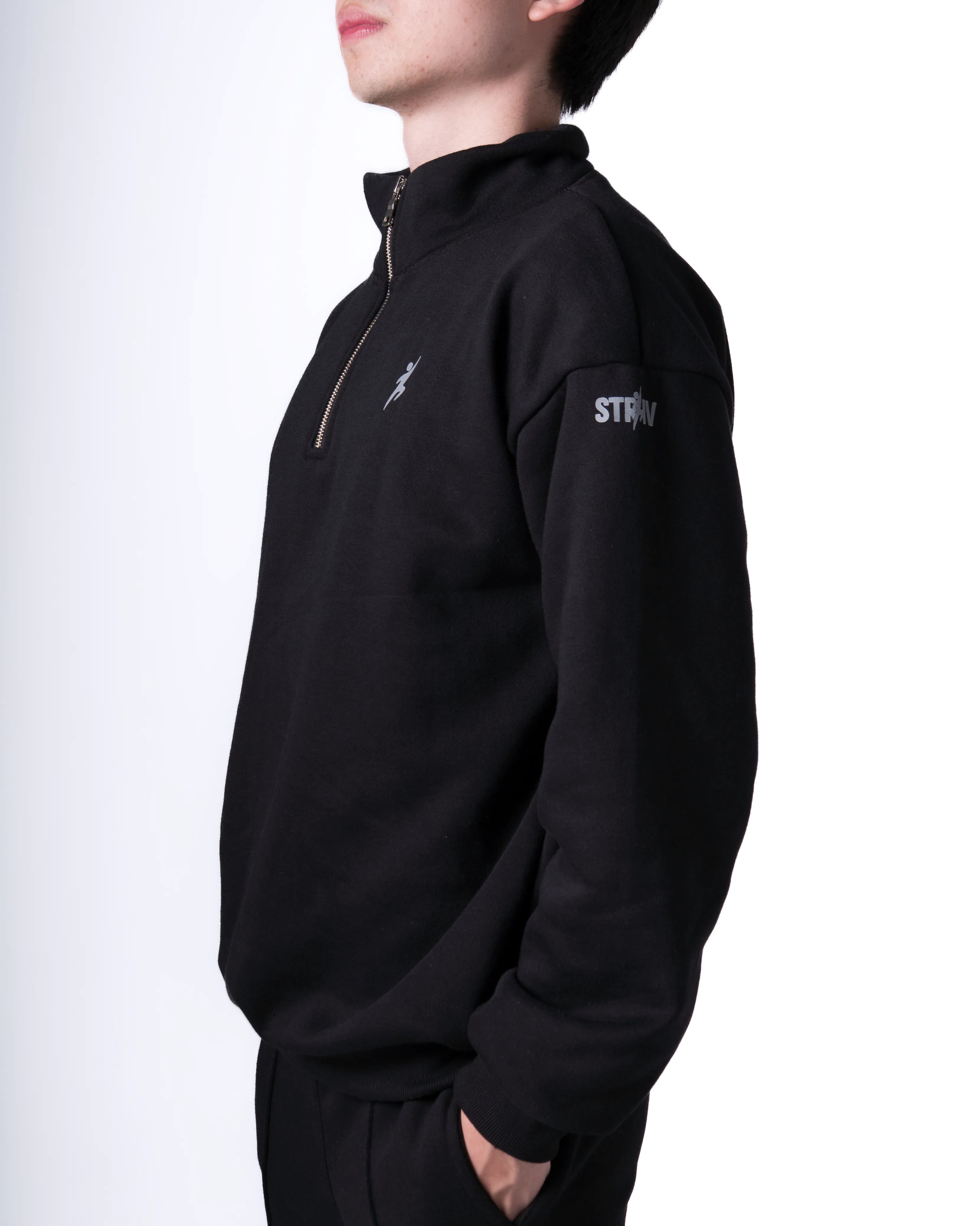 Person wearing a Black quarter-zip sweatshirt with branding on a white background
#color_black