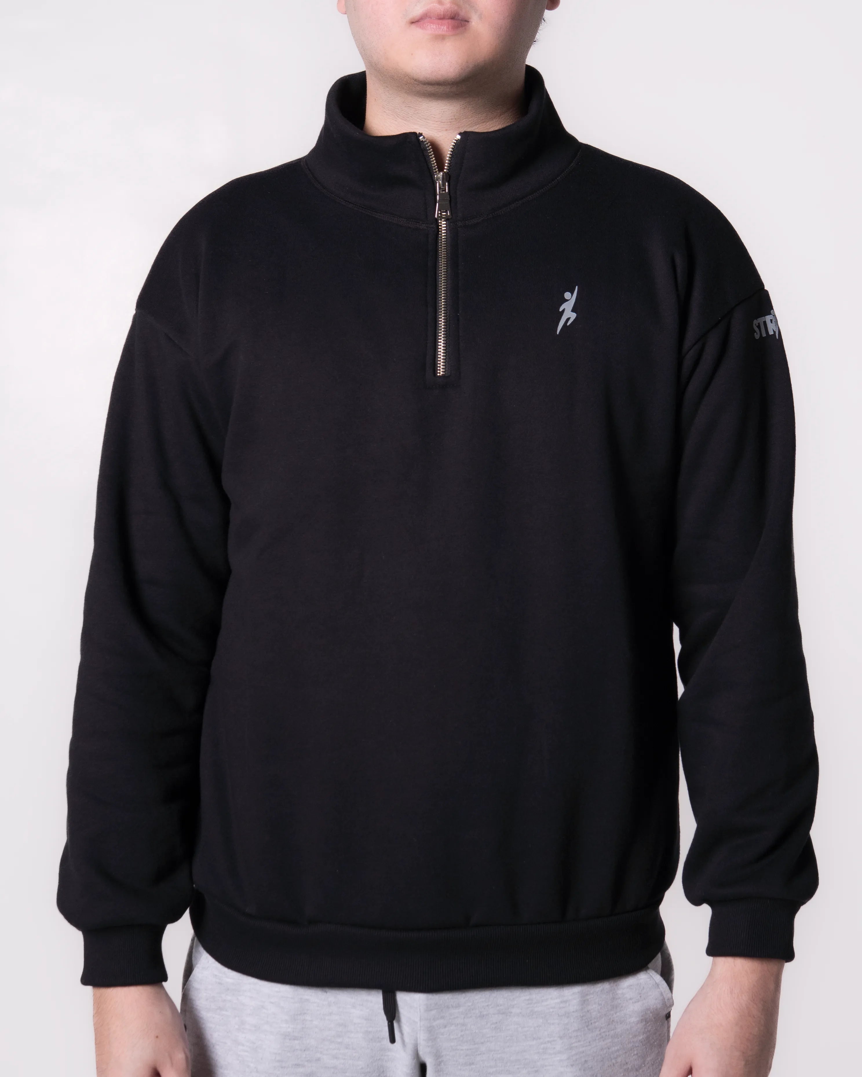 Person wearing a Black quarter-zip sweatshirt with a logo on a white background
#color_black