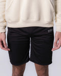 Person wearing Black shorts with a brand logo on a white background
#color_black