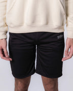 Person wearing Black shorts with a brand logo on a white background
#color_black
