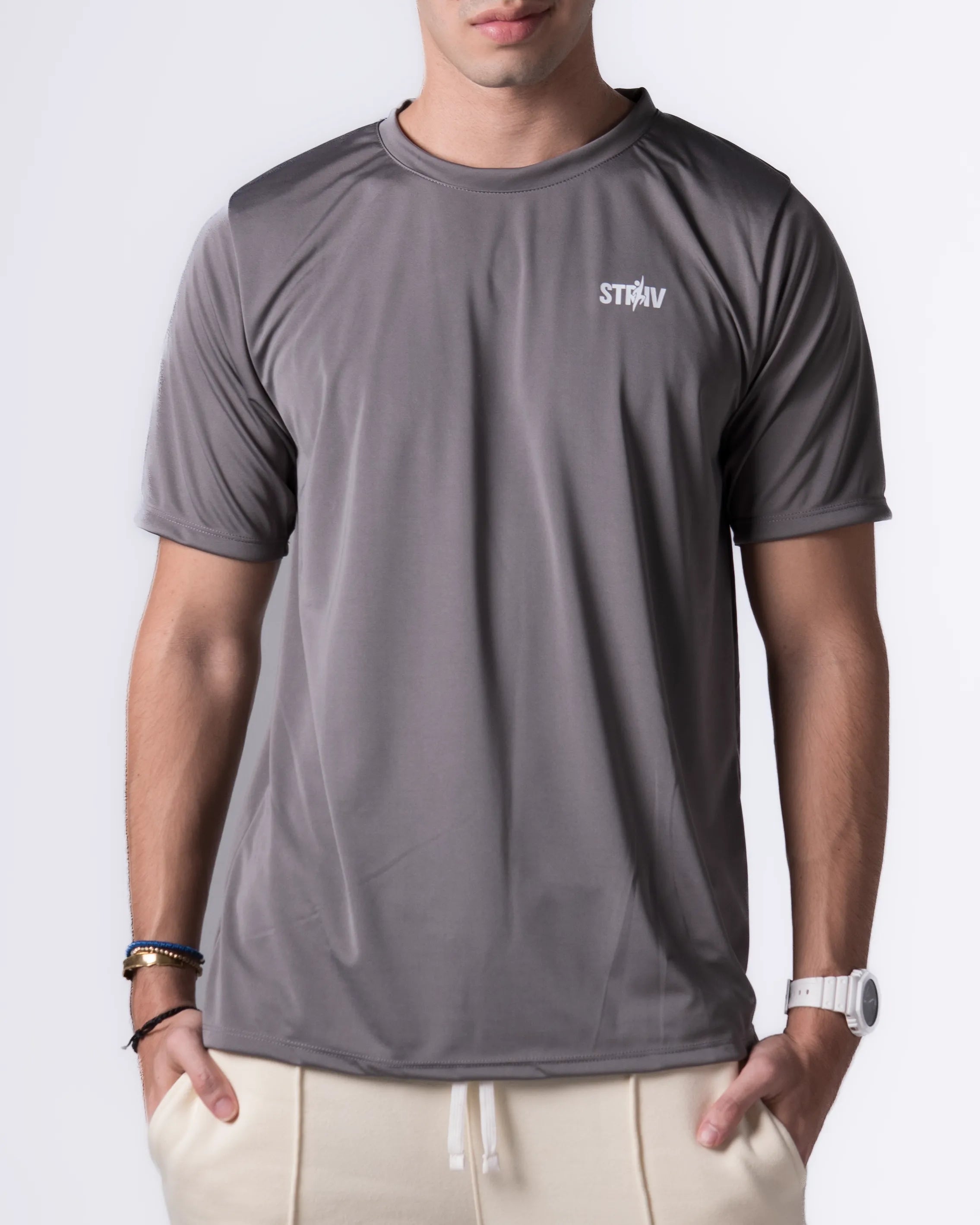 Person wearing a Gray athletic shirt with a brand logo on a white background
#color_gray